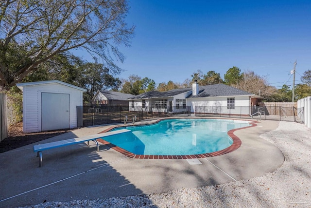 view of pool featuring a diving board, a patio area, and a storage shed