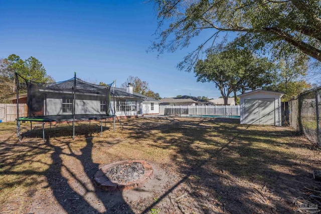 view of yard featuring a trampoline and a storage shed