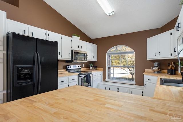 kitchen with white cabinets, vaulted ceiling, and appliances with stainless steel finishes