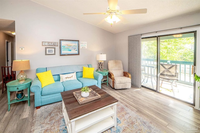 living room with lofted ceiling, ceiling fan, and wood finished floors