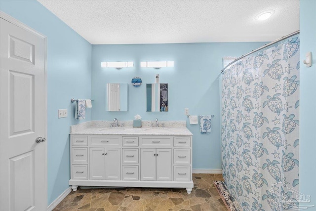 bathroom with vanity, curtained shower, and a textured ceiling