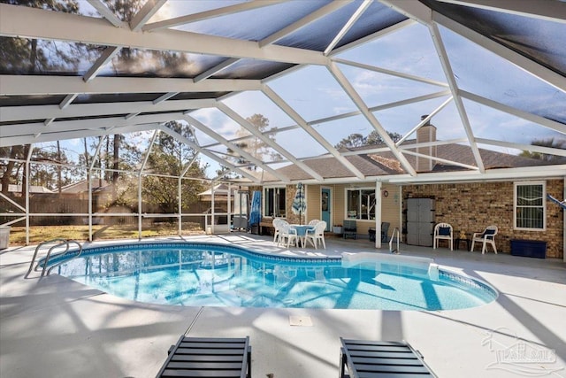 view of pool featuring glass enclosure and a patio area