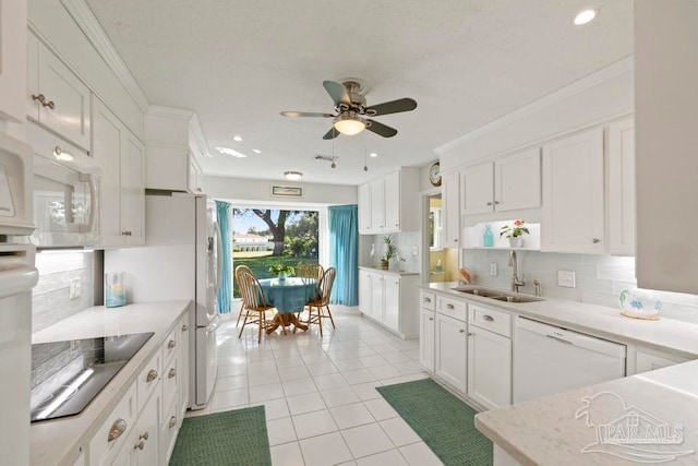 kitchen featuring white cabinetry, tasteful backsplash, sink, and white appliances