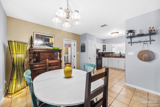 tiled dining room with sink and a notable chandelier