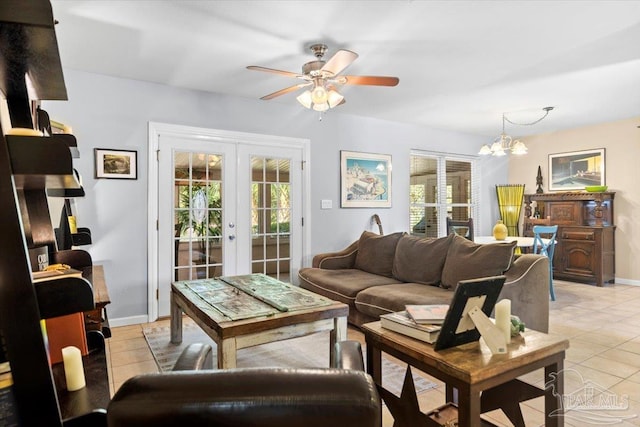 living room with ceiling fan with notable chandelier, light tile patterned floors, and french doors