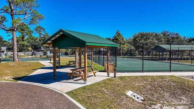 view of tennis court featuring a yard