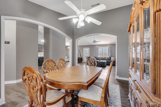 1096 Adrian Way, Milton, FL 32583 - dining area featuring arched walkways, a ceiling fan, baseboards, and dark wood-style flooring