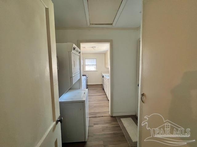 laundry area with stacked washer / dryer and hardwood / wood-style floors