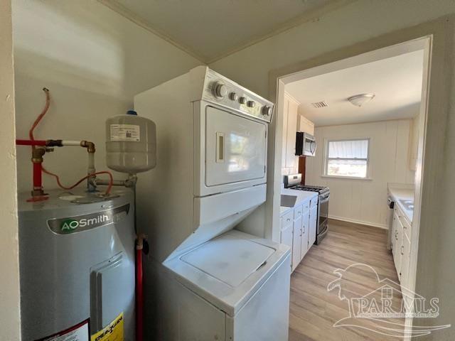 laundry room featuring light hardwood / wood-style flooring, stacked washing maching and dryer, and electric water heater