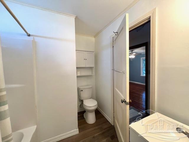 bathroom with toilet, ceiling fan, hardwood / wood-style flooring, and tub / shower combination