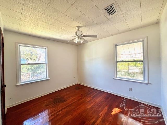 spare room with ceiling fan and dark wood-type flooring