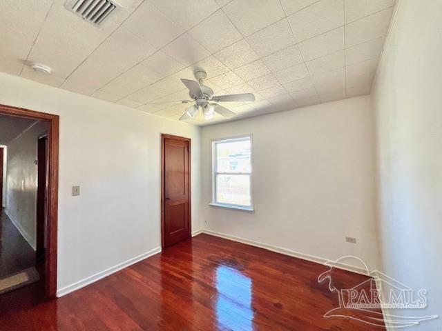 empty room with ceiling fan and dark wood-type flooring