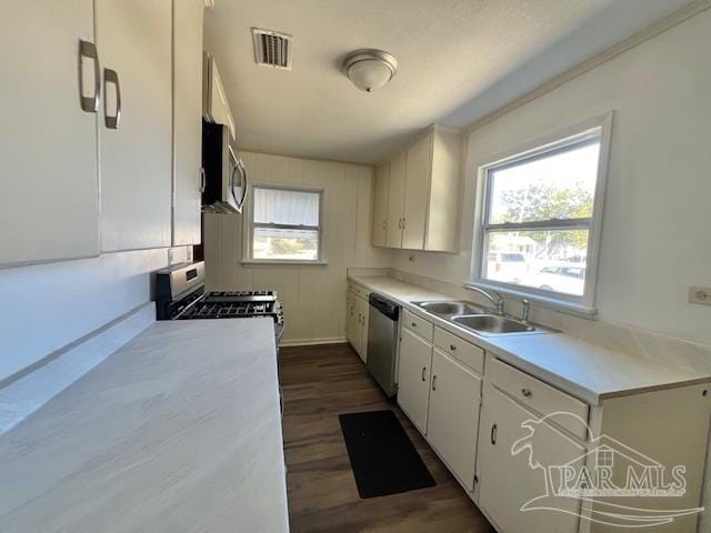 kitchen with sink, white cabinets, dark hardwood / wood-style floors, and appliances with stainless steel finishes