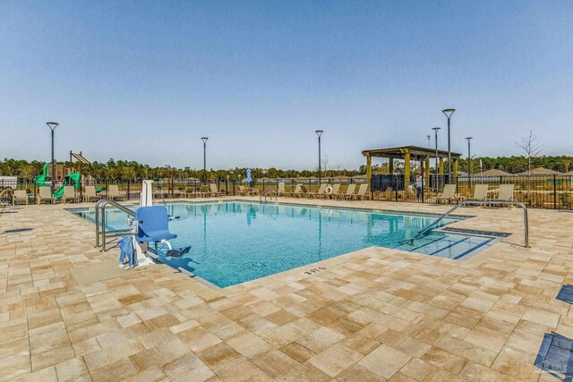 view of swimming pool with a patio and a playground