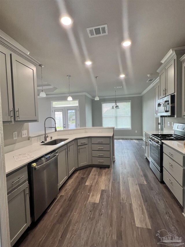 2305 Habersham Ln, Cantonment, FL 32533 - kitchen with stainless steel appliances, gray cabinetry, a sink, ornamental molding, and dark wood-style floors