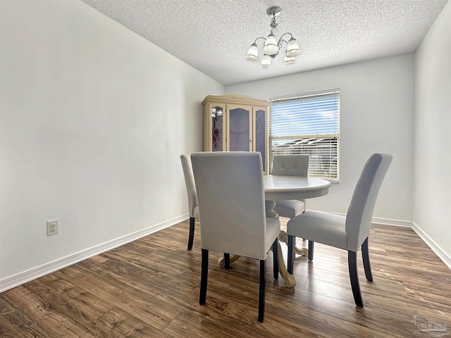 dining space with dark wood-type flooring, a notable chandelier, and a textured ceiling