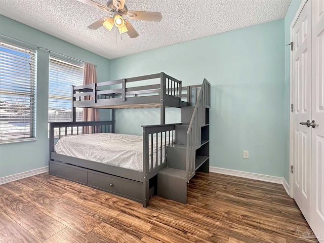 bedroom with ceiling fan, wood-type flooring, a closet, and a textured ceiling