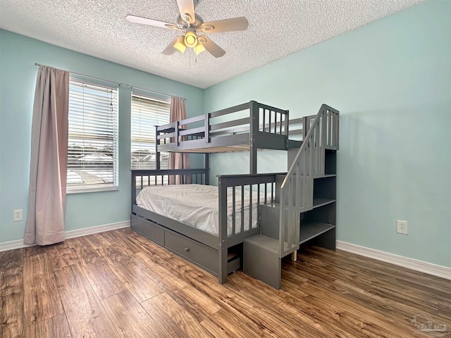 bedroom with hardwood / wood-style flooring, a textured ceiling, and ceiling fan