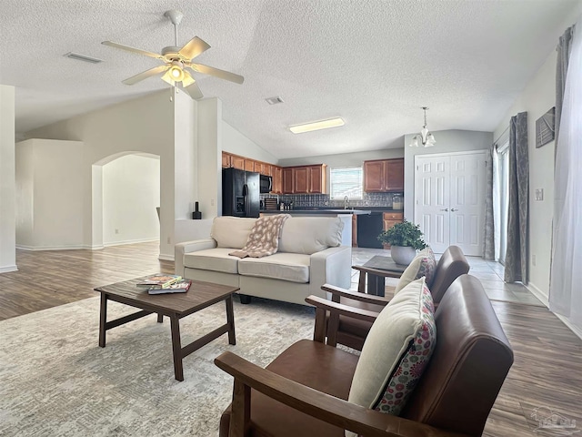 living room with light hardwood / wood-style flooring, sink, vaulted ceiling, and ceiling fan