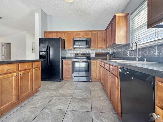 kitchen featuring sink, vaulted ceiling, light tile patterned floors, decorative backsplash, and black appliances