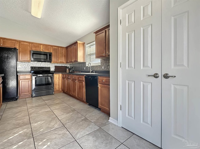 kitchen featuring vaulted ceiling, backsplash, light tile patterned floors, black appliances, and a textured ceiling