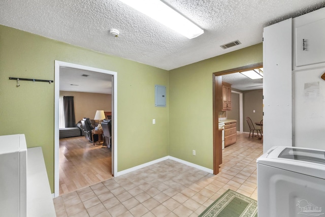 laundry area with washer / dryer, light tile patterned floors, electric panel, and a textured ceiling