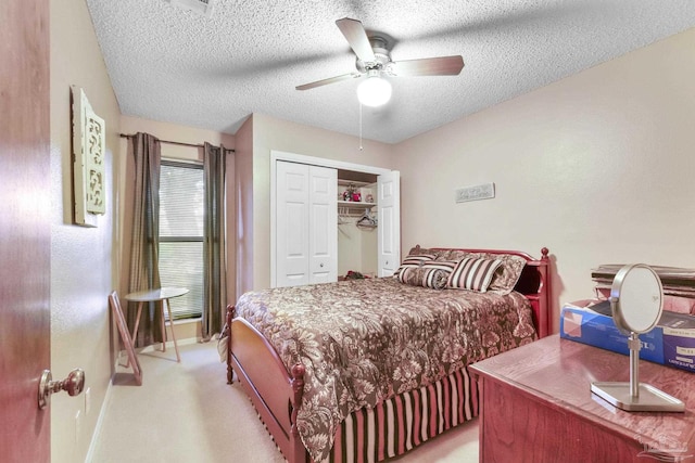 carpeted bedroom with a textured ceiling, ceiling fan, and a closet