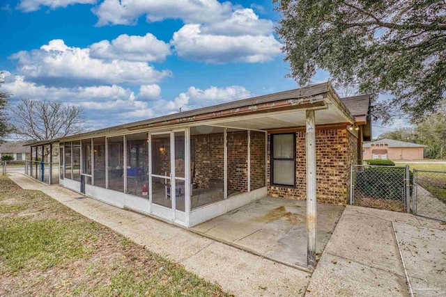 rear view of property featuring a patio area and a sunroom