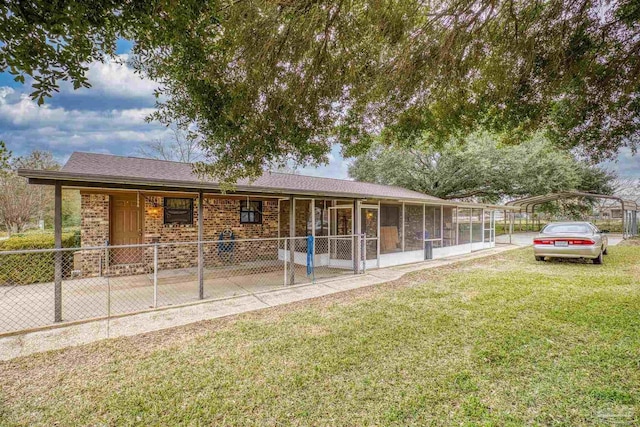 view of front facade featuring a front yard, a sunroom, and a carport