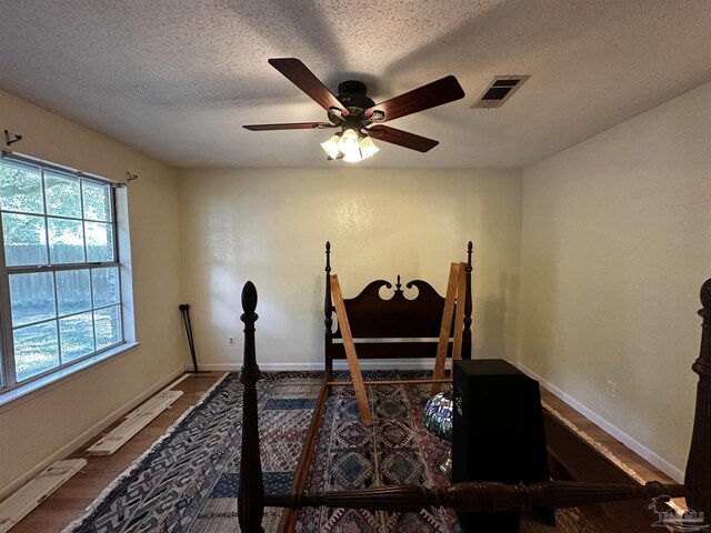 office with a textured ceiling, ceiling fan, and hardwood / wood-style flooring