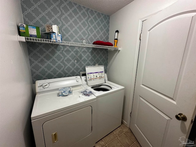 laundry room featuring a textured ceiling and washing machine and dryer