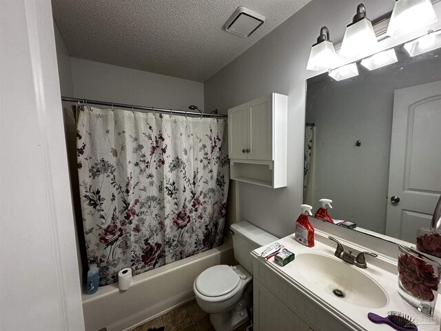 full bathroom with vanity, a textured ceiling, shower / tub combo, tile patterned floors, and toilet