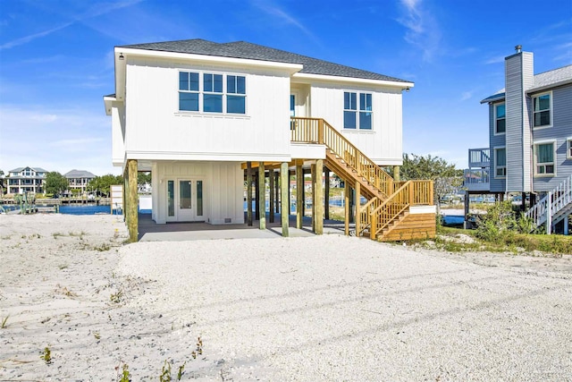 back of house featuring a carport and a water view