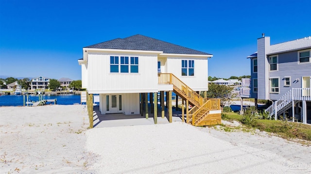 back of house featuring a carport and a water view