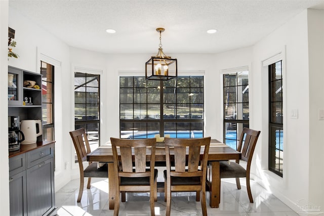 dining area with a wealth of natural light, marble finish floor, a textured ceiling, and recessed lighting