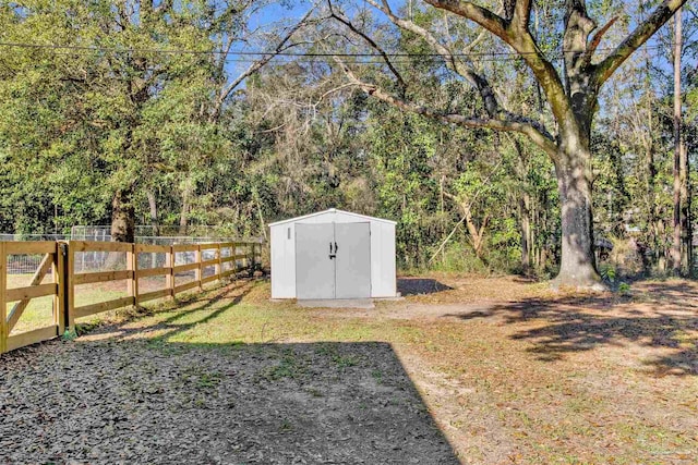 view of yard featuring an outdoor structure, fence, and a shed