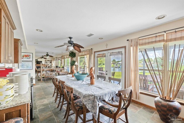 dining area featuring french doors and a water view