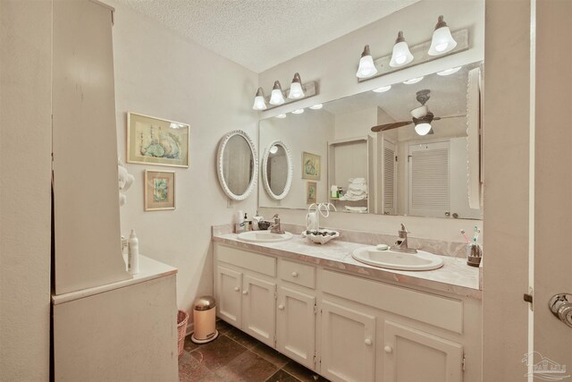 bathroom with vanity, ceiling fan, and a textured ceiling