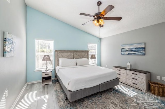 bedroom featuring multiple windows, wood-type flooring, lofted ceiling, and ceiling fan