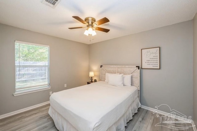 bedroom with light hardwood / wood-style floors and ceiling fan