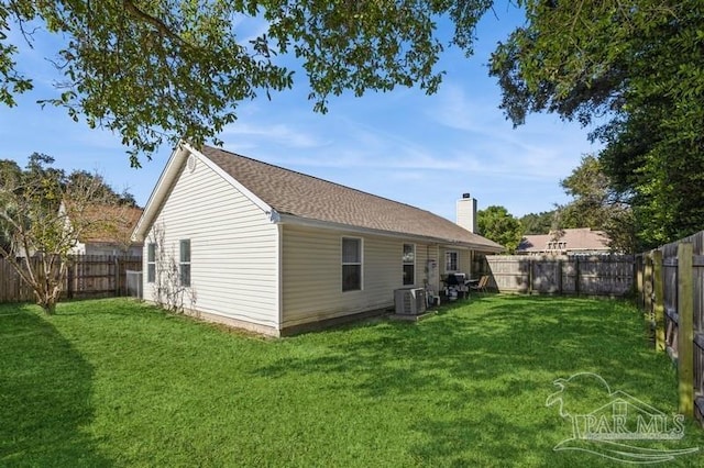 back of house with a yard and central air condition unit