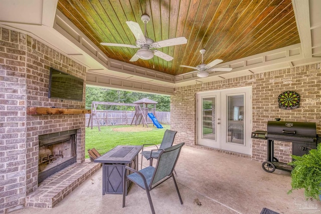 5622 Dunridge Dr, Pace, FL 32571 - fenced backyard featuring an outdoor brick fireplace, a playground, a patio, french doors, and a grill