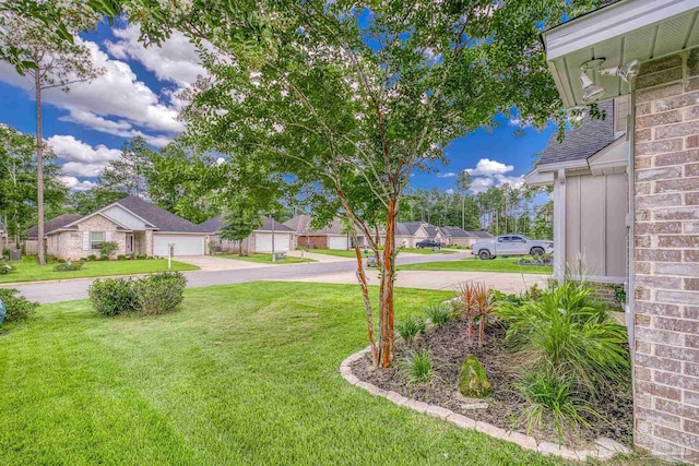 5622 Dunridge Dr, Pace, FL 32571 - view of grassy yard featuring concrete driveway, a residential view, and a garage