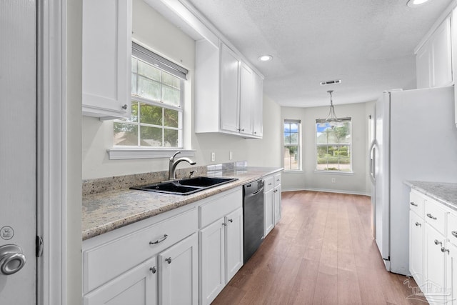 3514 Silvertree Ln, Pensacola, FL 32504 - kitchen featuring a sink, dishwasher, freestanding refrigerator, white cabinets, and healthy amount of natural light