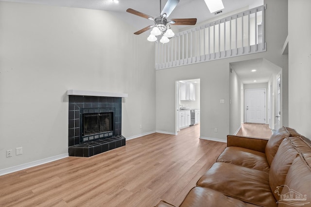 3514 Silvertree Ln, Pensacola, FL 32504 - living area featuring a high ceiling, wood finished floors, ceiling fan, baseboards, and a tiled fireplace