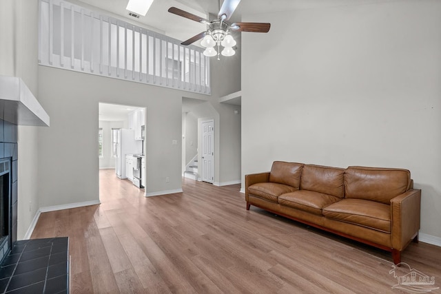 3514 Silvertree Ln, Pensacola, FL 32504 - living room featuring ceiling fan, a fireplace, light wood-type flooring, stairway, and baseboards