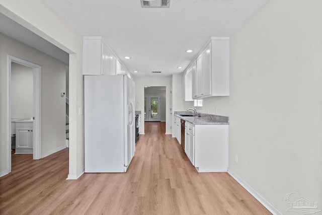 3514 Silvertree Ln, Pensacola, FL 32504 - kitchen with white fridge with ice dispenser, a sink, light wood-style floors, white cabinetry, and recessed lighting