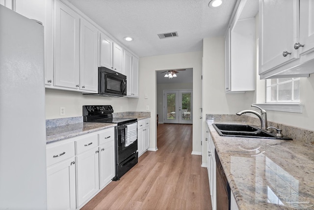 3514 Silvertree Ln, Pensacola, FL 32504 - kitchen with black appliances, white cabinetry, a sink, light wood-type flooring, and french doors