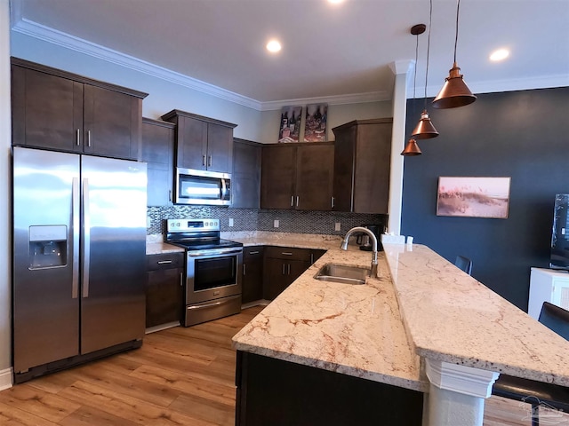 kitchen with pendant lighting, appliances with stainless steel finishes, dark brown cabinetry, tasteful backsplash, and sink