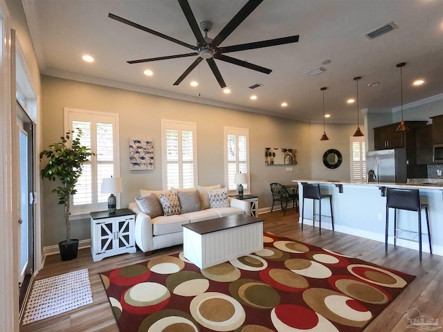 living room featuring ceiling fan, dark hardwood / wood-style floors, and ornamental molding